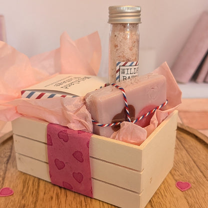 Gift basket with soap bars and a jar on a wooden surface